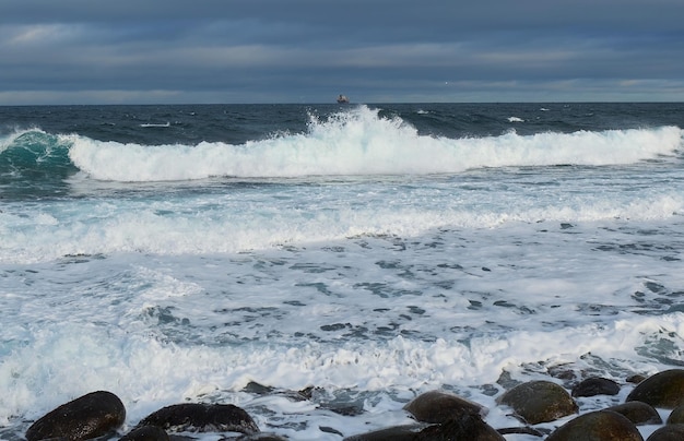 Mächtige Wellen, die an einem felsigen Strand zermalmen