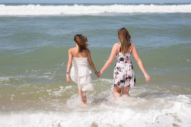 Mädchen am Meer Zwei junge Frauen kommen in Rückansicht ins Meer