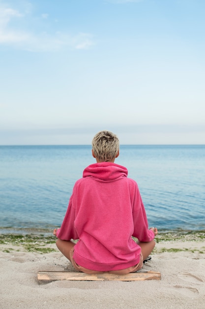 Mädchen am Strand im Lotussitz