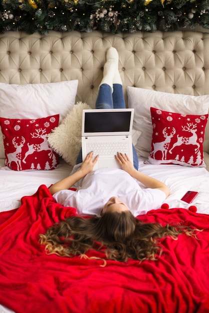 Mädchen arbeitet online, von zu Hause aus, liegt auf dem Bett, Videolink