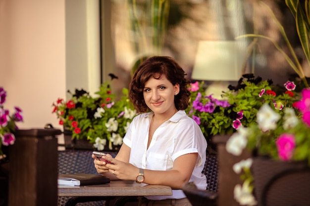 Mädchen arbeitet sitzend an einem Tisch in einem Café auf der Straße