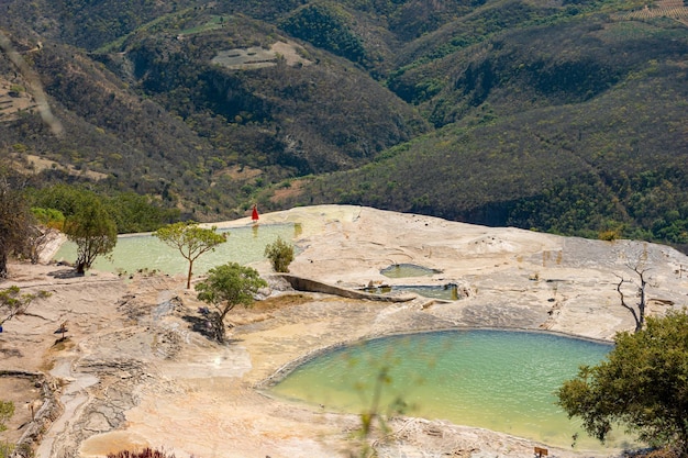 Mädchen auf dem Gipfel eines weißen Berges mit blauen Seen und Quellen in Mexiko hierve del agua