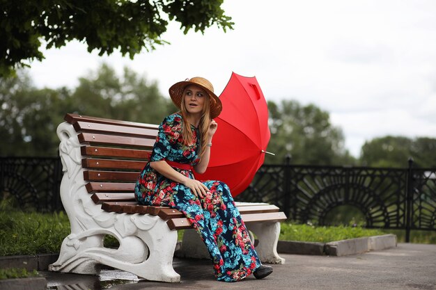 Mädchen auf der Straße mit einem Regenschirm für einen Spaziergang an einem Sommertag