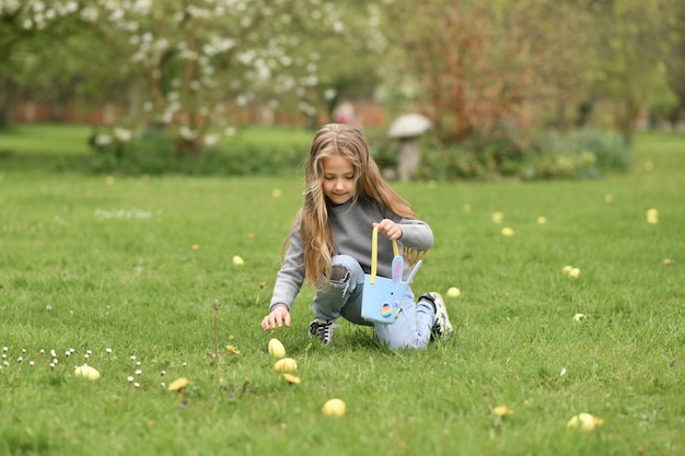 Mädchen auf der Suche nach Eiern in einer Tasche für Ostern