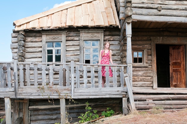 Mädchen auf der Terrasse eines alten Holzhauses