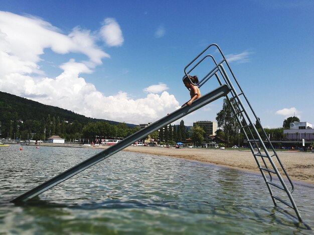 Mädchen auf der Wasserrutsche gegen den Himmel