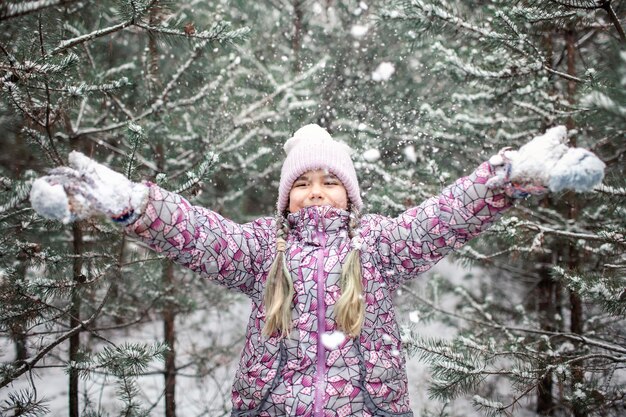 Foto mädchen auf einem mit schnee bedeckten baum im winter