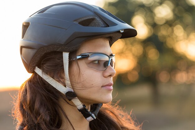 Mädchen auf einem Mountainbike im Gelände schönes Porträt eines Radfahrers bei Sonnenuntergang