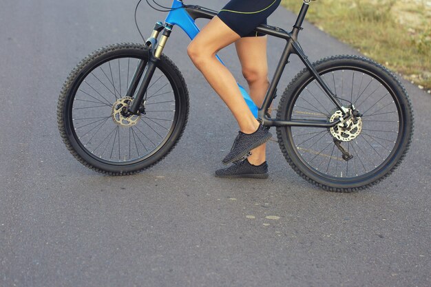 Mädchen auf einem Mountainbike im Gelände, schönes Porträt eines Radfahrers bei Sonnenuntergang