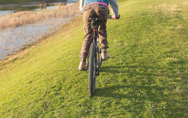 Mädchen auf einem Mountainbike im Gelände schönes Porträt eines Radfahrers bei Sonnenuntergang