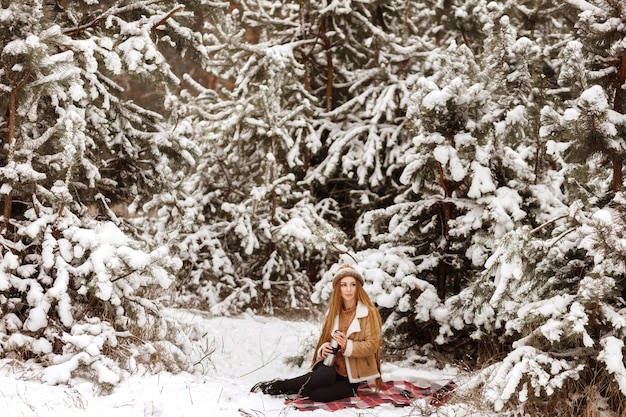 Mädchen auf einem Picknick im Winter im Wald auf einem Spaziergang