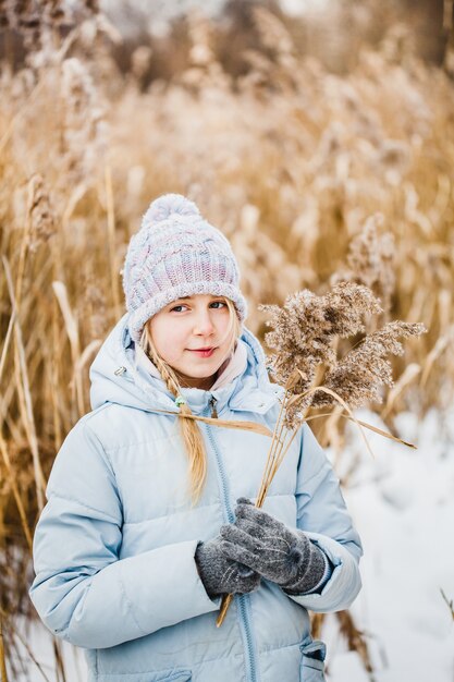 Mädchen auf einem Spaziergang im Wald, Gras und Schnee, Winterspaziergänge, Wald, Feld, Winterkleidung