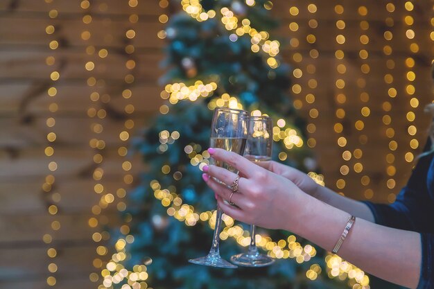 Mädchen auf Weihnachtshintergrund mit Champagner. Selektiver Fokus. Urlaub.