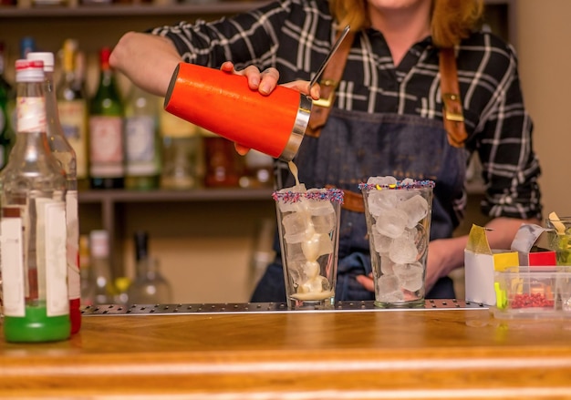 Mädchen-Barkeeper bereitet Cocktails zu. Mixology-Instrumente hinter der Bar