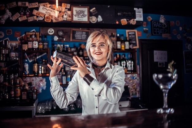 Mädchen-Barkeeper kreiert einen Cocktail im Schankraum