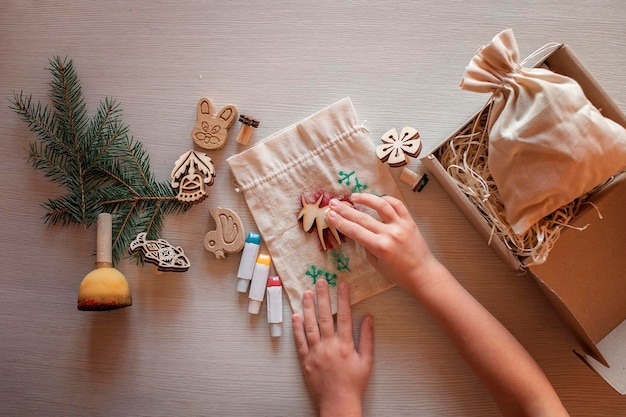 Foto mädchen beim basteln für festliche geschenke mit holzstempeldrucktechnik