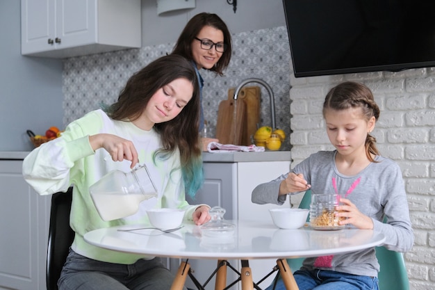 Mädchen beim Frühstück sitzen am Tisch in der Hauptküche, Schwestern im Teenageralter