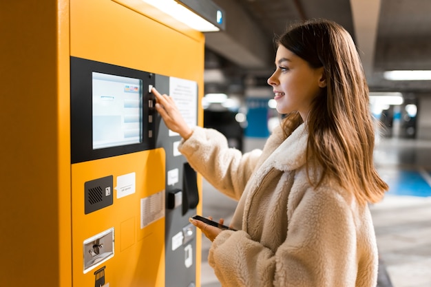 Mädchen bezahlt für Ticket in Parkuhr.