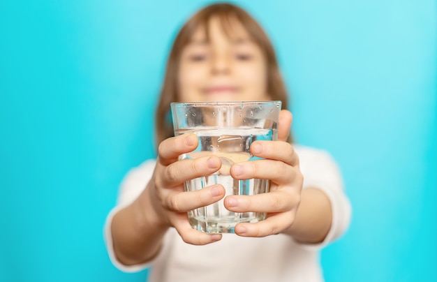 Mädchen bietet Wasser aus einem Glas