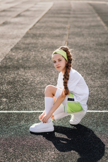 Mädchen, das an einem sonnigen Sommerabend joggt und auf Laufband legt