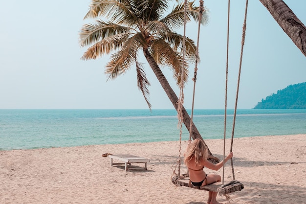 Mädchen, das auf einer Schaukel am Meer schwingt