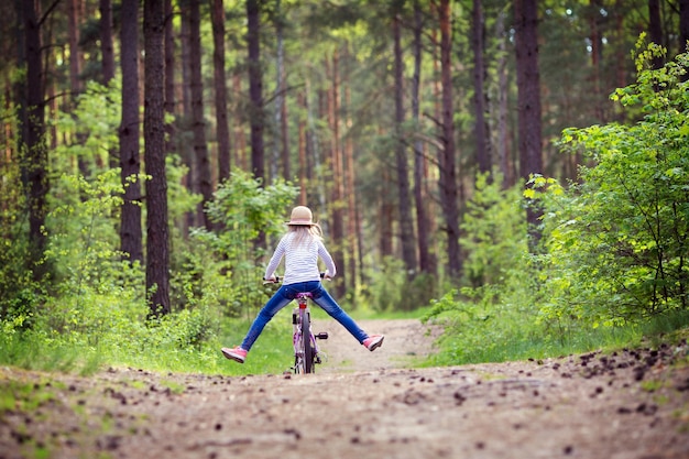 Mädchen, das auf ihrem Fahrrad durch den Wald fährt