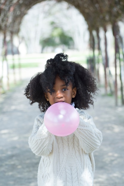 Mädchen, das Ballon draußen bläst