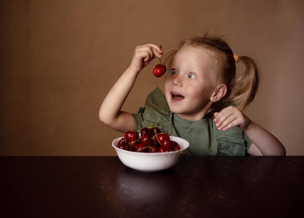 Mädchen, das Beeren am Tisch isst