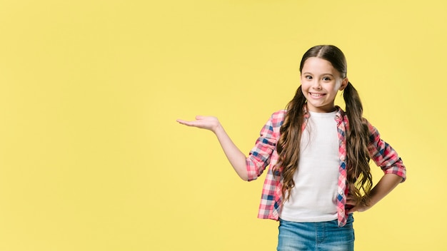 Foto mädchen, das beiseite mit der hand im studio steht