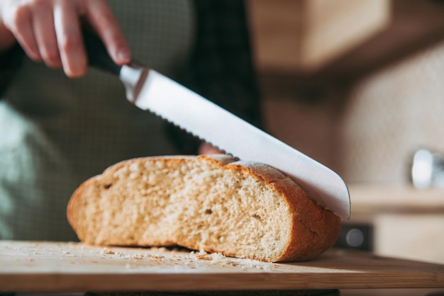 mädchen, das brot, hausmannskost, küchenhintergrund schneidet