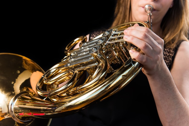 Mädchen, das das französische Horn spielt