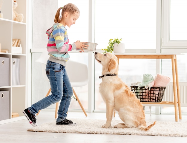 Mädchen, das dem Hund Nahrung gibt