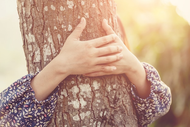 Mädchen, das den Baum umarmt