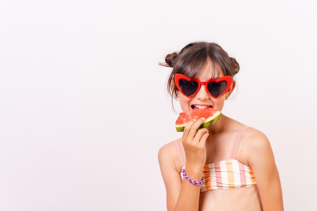 Mädchen, das den Sommer genießt, der ein Wassermelone-Schulferienkonzept isst Weißer Hintergrund