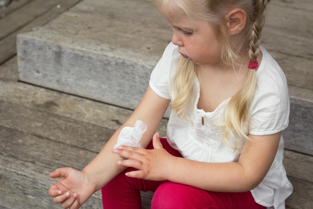 Mädchen, das dermatologische Creme auf Haut aufträgt