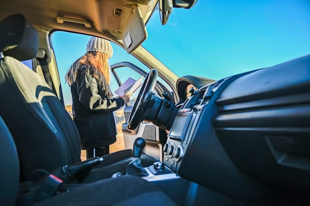 Mädchen, das die Karte der Route betrachtet, um mit dem Auto zu folgen