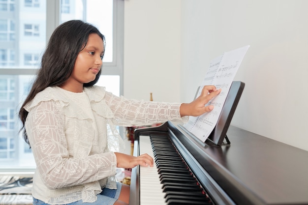 Mädchen, das die Komposition am Klavier spielt