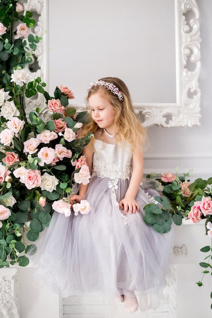 Mädchen, das ein elegantes Kleid trägt, das in einem Studio aufwirft