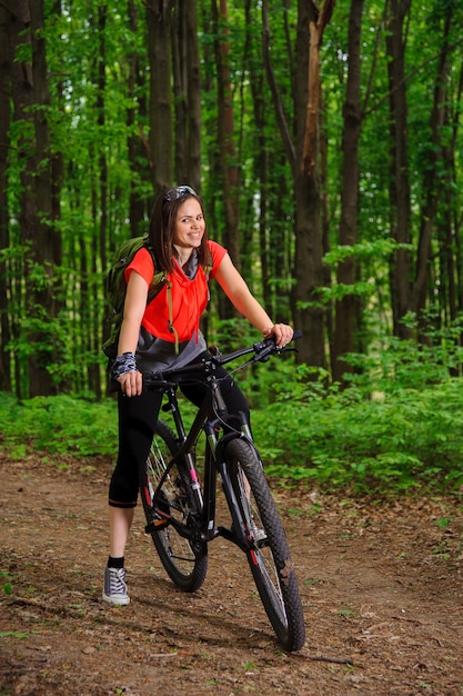 Mädchen, das ein Fahrrad im Wald reitet