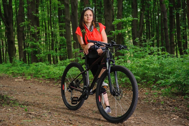 Mädchen, das ein Fahrrad im Wald reitet