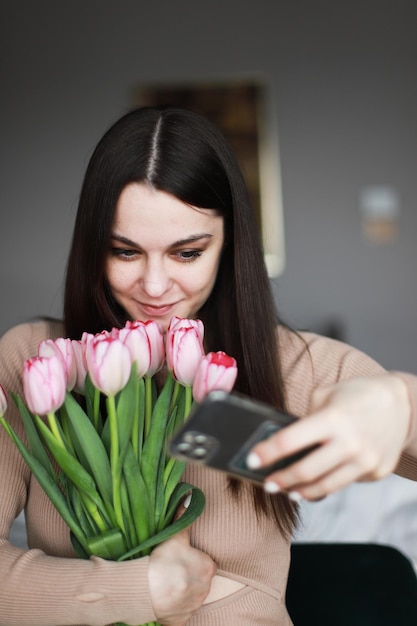 Mädchen, das ein selfie mit Blumen macht