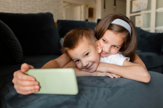 Mädchen, das ein Selfie zu Hause mit ihrem Bruder nimmt