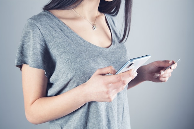 Mädchen, das ein Telefon und eine Bankkarte in den Händen hält