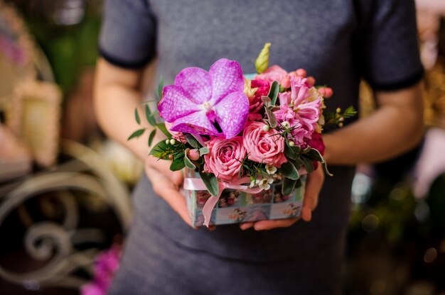 Mädchen, das eine kleine schöne Schachtel der Blumen hält