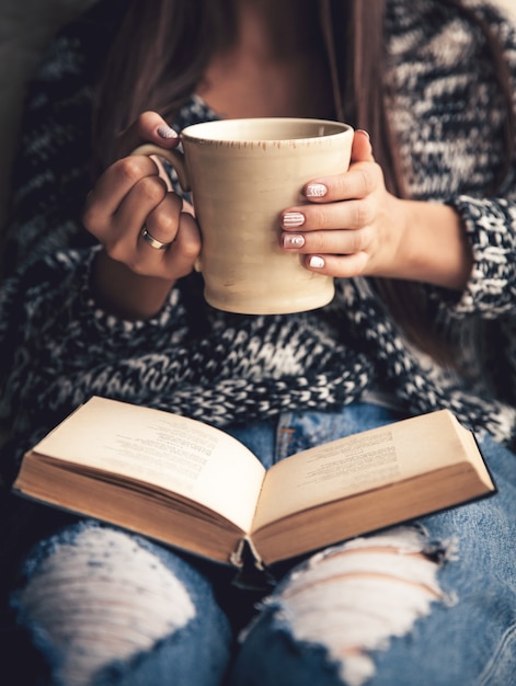 Mädchen, das eine Pause mit Tasse frischem Kaffee nach dem Lesen von Büchern oder Lernen hat