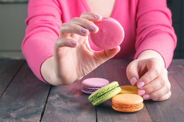 Mädchen, das eine Tasse Kaffee mit Macaron hält