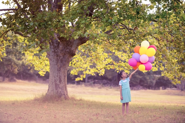 Mädchen, das einen Ballon im Park hält