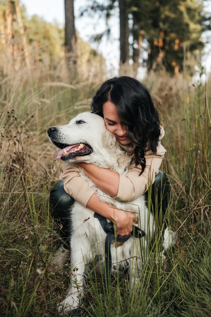 Mädchen, das einen Golden Retriever-Hund auf dem Feld umarmt