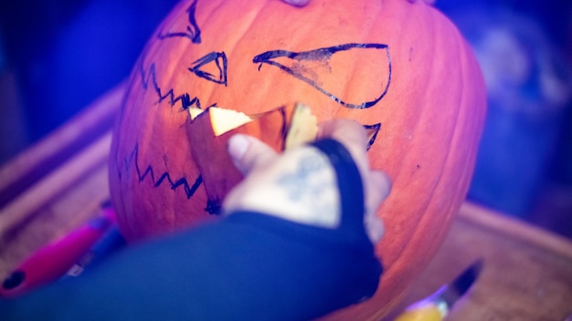 Mädchen, das einen Halloween-Kürbis macht