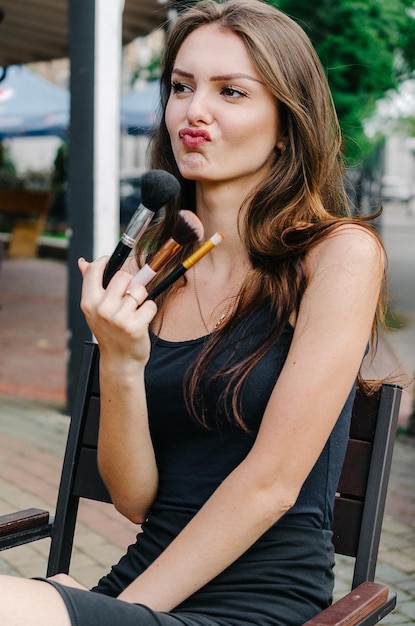 Mädchen, das einen Pinsel für Make-up hält